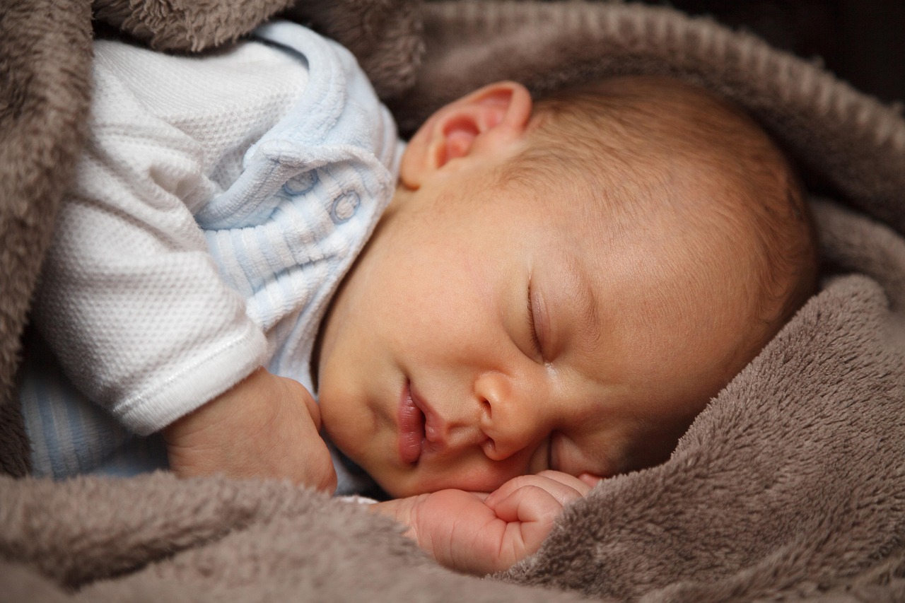 Pasgeboren baby slaapt vredig in een mand met witte deken
